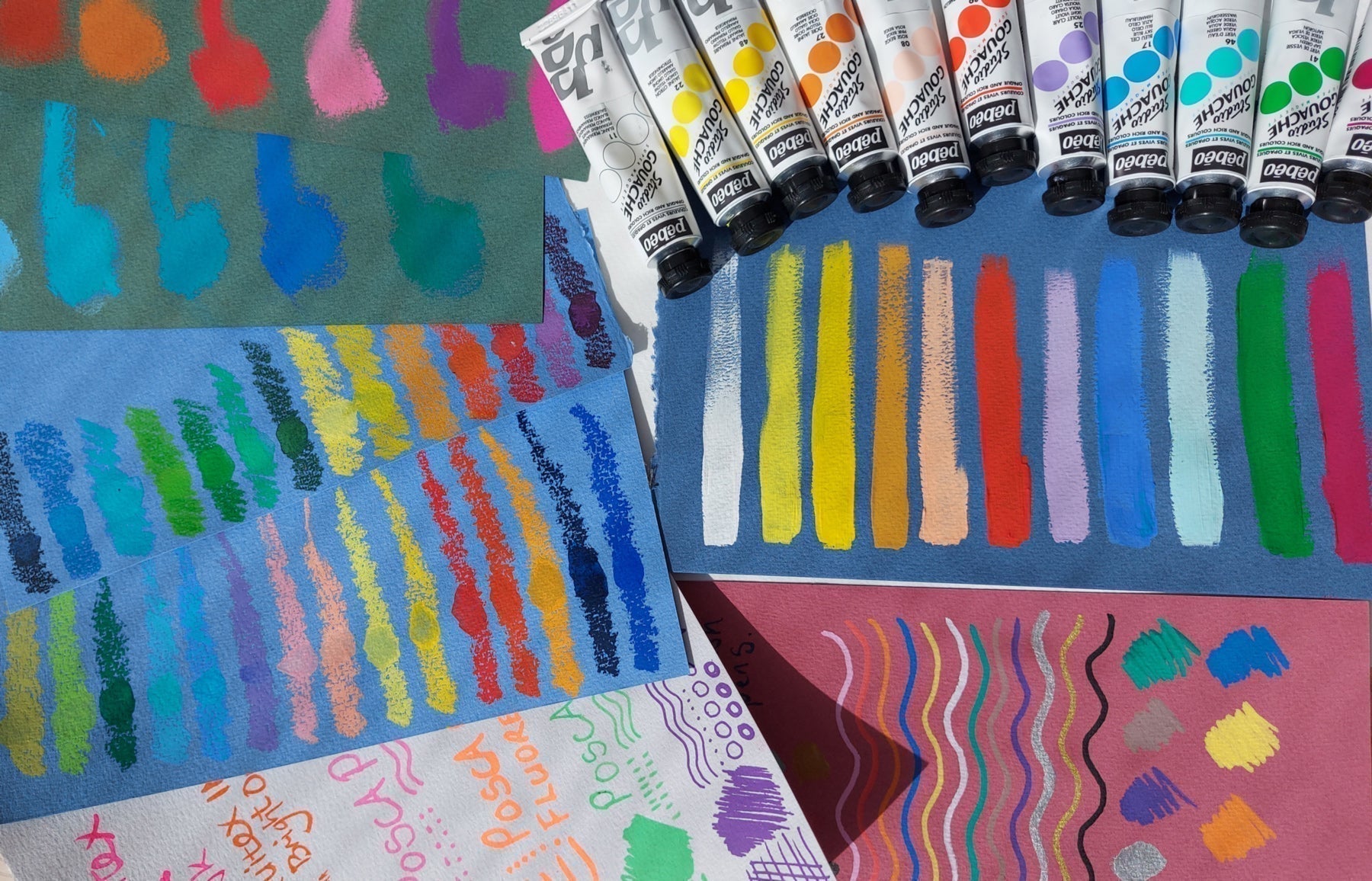 Different coloured sheets of Fabriano paper used to create test strips with Inktense pencils and Pebeo Gouache paint.