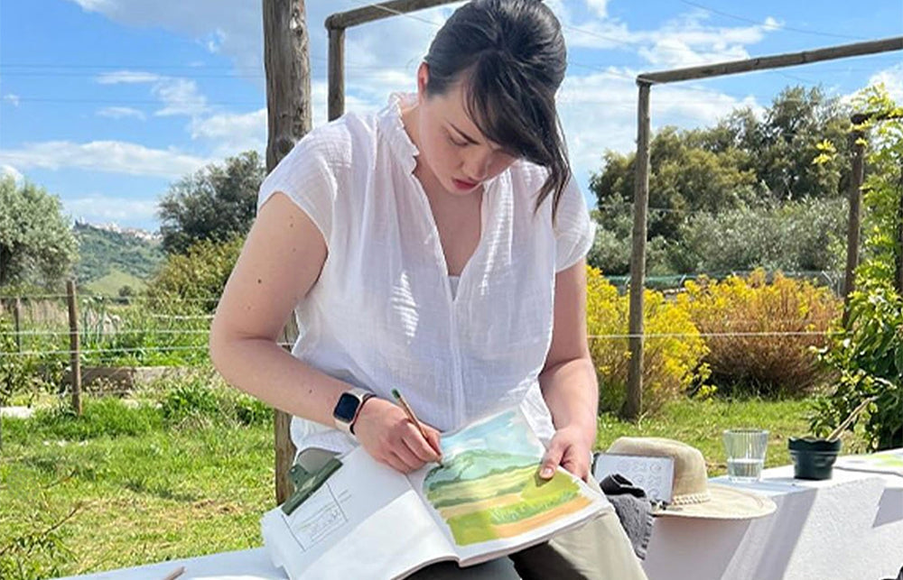 Artist Katie Moody painting in her sketchbook