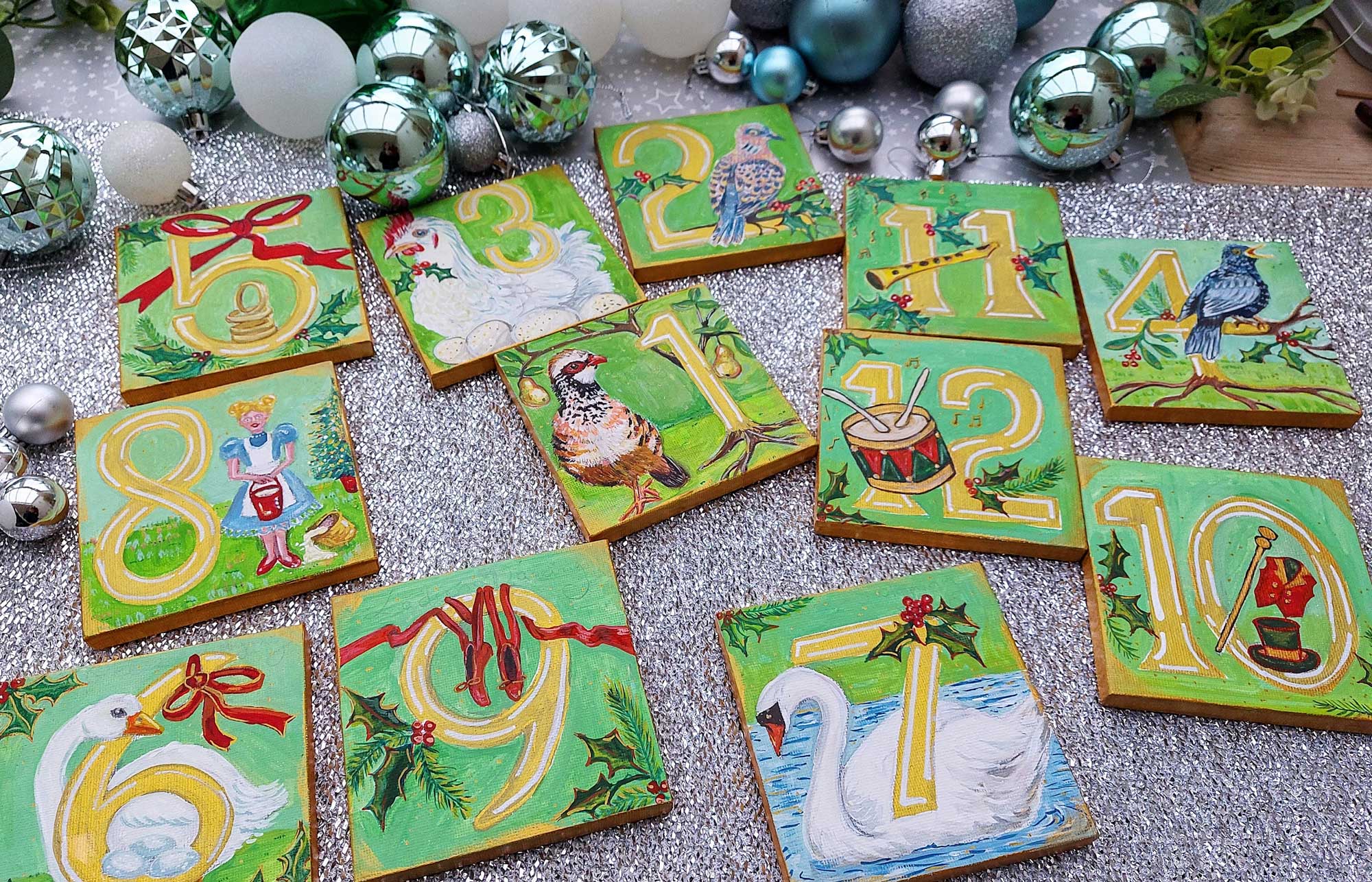 Multiple Mini canvases, each one painted with an image illustrating the 12 days of Christmas.