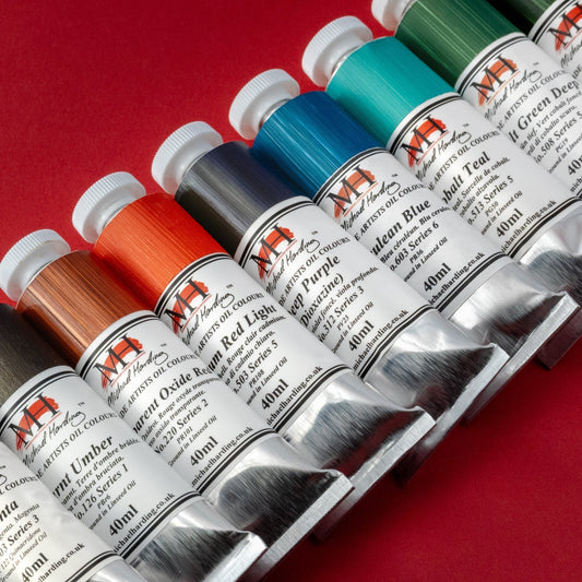 Row of colorful paint tubes showing different paint tube symbols meaning and series numbers.