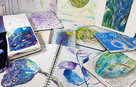 Several sketchbooks open with organic drawings in bright colours; purples, blues, yellows, greens and lilac.