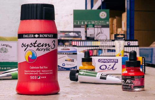 Multiple Daler Rowney products such as system3 acrylics, Graduate oil paint, acrylic inks and watercolour sets laid out.