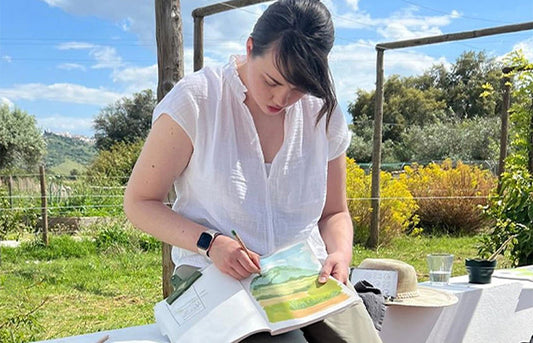 Artist Katie Moody painting in her sketchbook