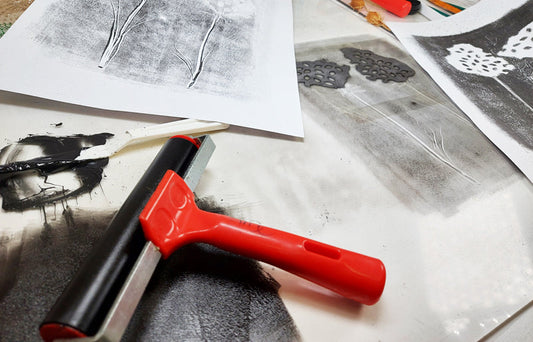 mono printing acetate sheet inked with an organic flower design and with two printed organic prints either side of it.