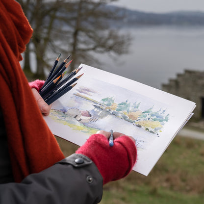 A person using Derwent Watercolour Pencils to draw/paint in the Lake District