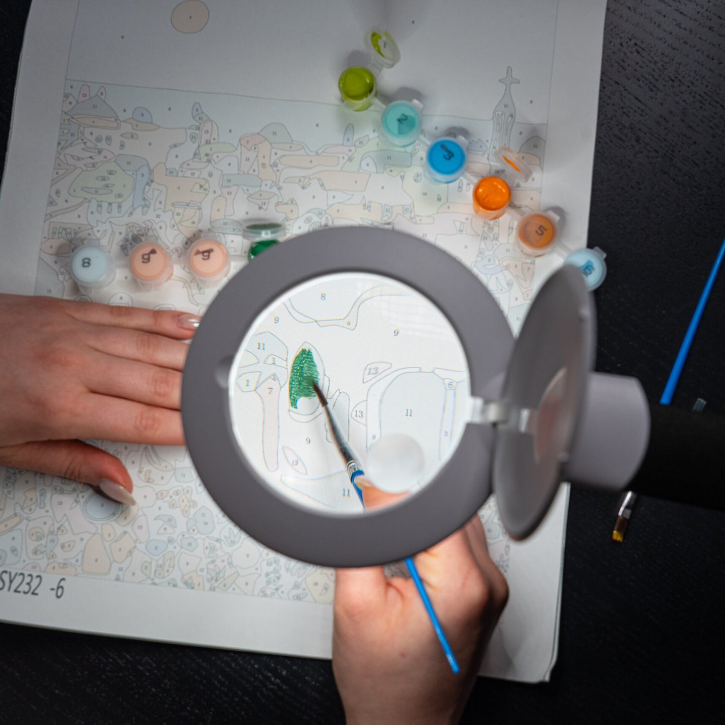 Person using the Daylight Halo Go 2 Lamp to paint in a colouring book