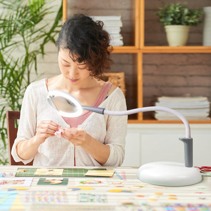 Daylight Company Magnificent Pro – 3-in-1 Magnifying Lamp in use by a woman crafting at a table.