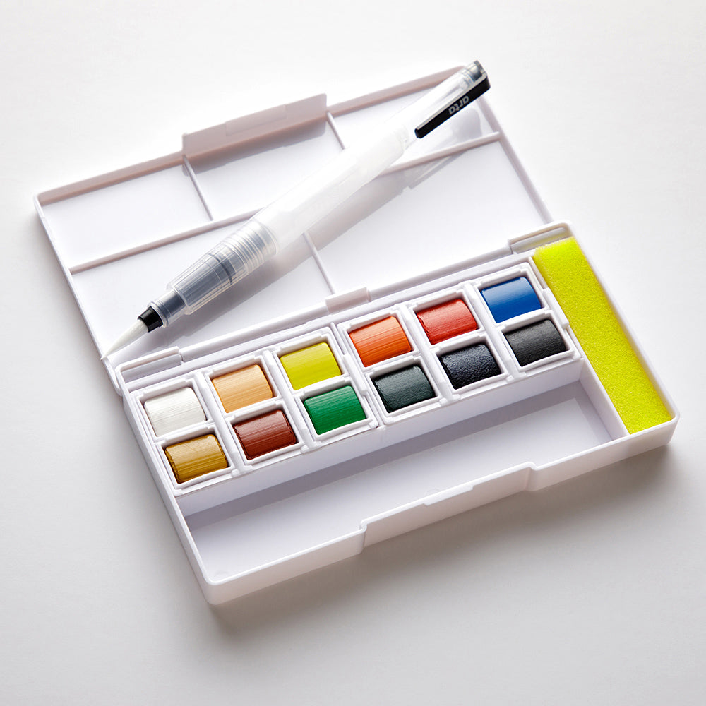 Open watercolor set with waterbrush on a white background