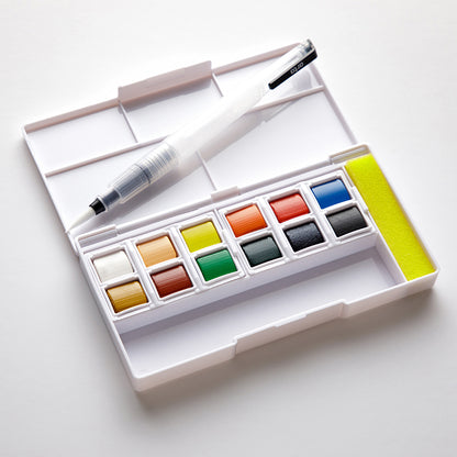 Open watercolor set with waterbrush on a white background